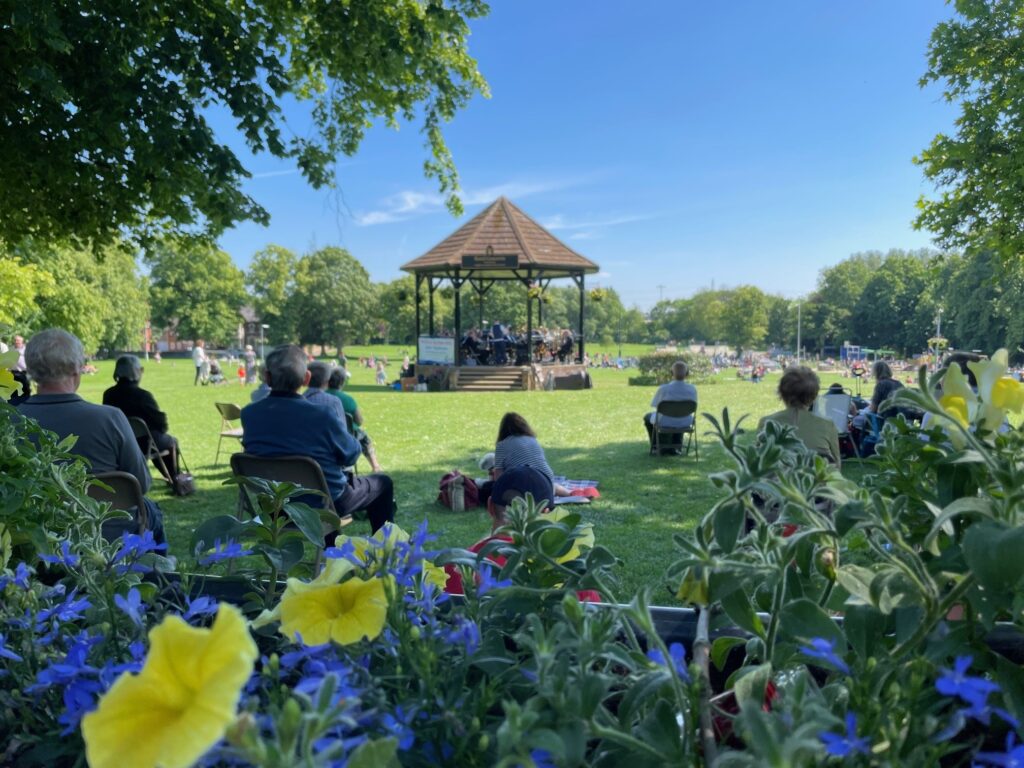 Parsons Close band plays on bandstand while audience listens